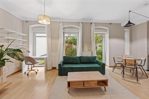 柏林Arbio I 1A Rooms & Apartments Prenzlauerberg Berlin的客厅配有绿色沙发和桌子