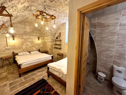 尚勒乌尔法Taşkıran Boutique Hotel的一间设有两张床和卫生间的客房