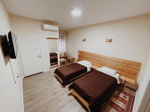 戈里察At Pikotiko's - Korca City Rooms for Rent的酒店客房设有两张床和电视。