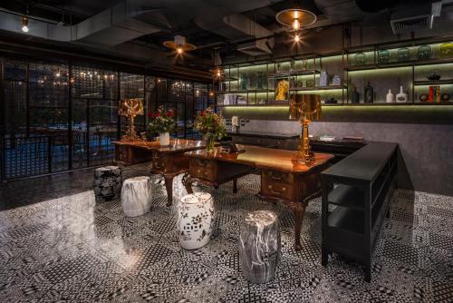 曼谷PASSA Hotel Bangkok的一间酒吧,在一间房间里设有桌子和长凳