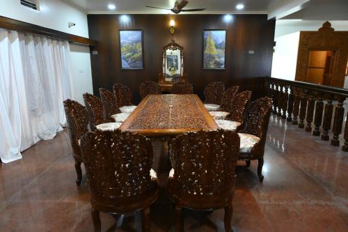 哈桑Amayaa Courtyard Homestay的一间带长桌和椅子的用餐室