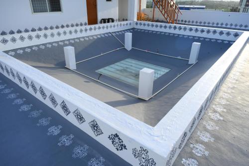 哈桑Amayaa Courtyard Homestay的房屋一侧带长凳的游泳池
