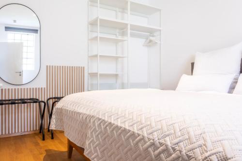 梅明根stycoz - Modernes Loft - 80 m2 - Küche - Parken的卧室配有白色的床和镜子