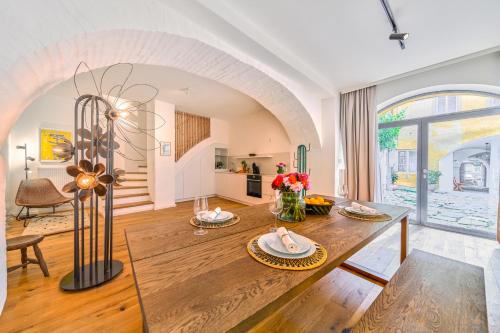 多瑙河畔克雷姆斯Smile Apartments "Lesehof"的一间带木桌的客厅和一间餐厅