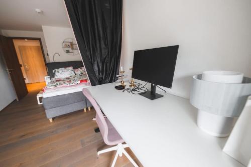 莱克斯Cosy, stylish new 2-bedroom flat with spa and gym的客房设有一张桌子、一台电视和一张床