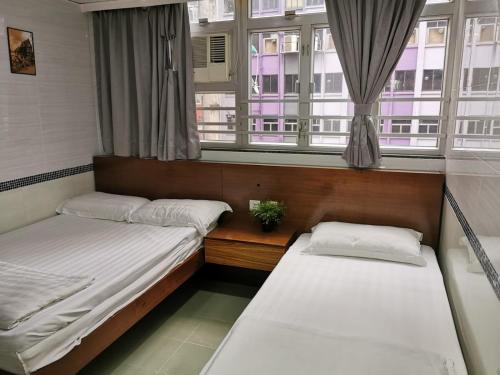 香港香港百乐宾馆 Best-B&B的带2扇窗户的客房内的2张床