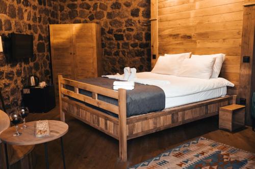 阿尔特温Lome Çiftliği Otel ve Restoran的卧室配有一张床铺,位于带木墙的房间内