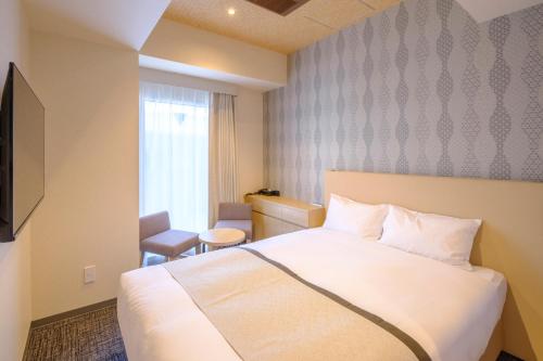 东京Tosei Hotel Cocone Tsukiji Ginza Premier的酒店客房设有白色的床和窗户。