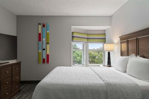 纽波特纽斯房纽波特纽斯 - 机场 - 奥斯特区域汉普顿酒店及套的一间卧室设有一张大床和一个窗户。