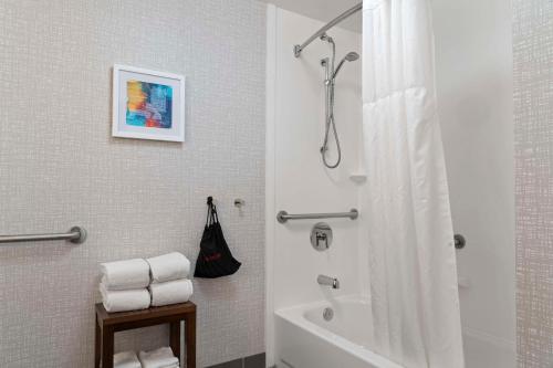 纽波特纽斯房纽波特纽斯 - 机场 - 奥斯特区域汉普顿酒店及套的浴室配有浴缸和淋浴及浴帘