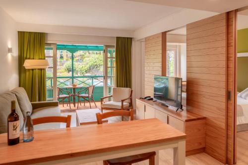 下布雷尼亚圣豪尔赫庄园酒店的客厅配有电视、床和桌子