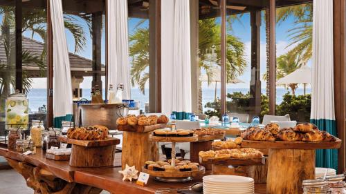 Shoal Bay VillageZemi Beach House, LXR Hotels & Resorts的一张带面包和糕点自助餐的桌子