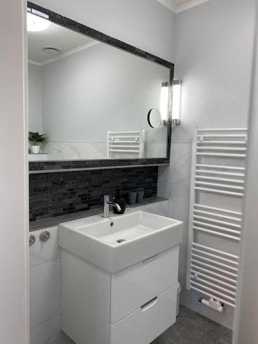 Rehburg-LoccumRehburger Landhaus的白色的浴室设有水槽和镜子