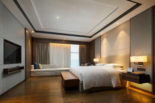 新昌新昌万怡酒店的一间卧室配有一张大床和一张沙发