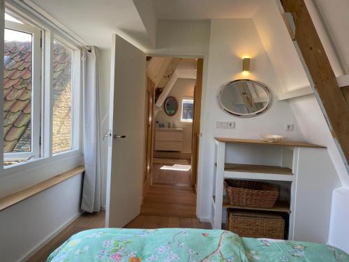 登霍伦Het Heertje的一间设有一张床的客房和一个带窗户的走廊