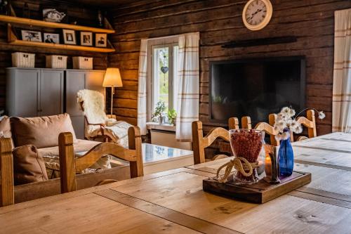 罗瓦涅米Kotatuli Forest Lodge的客厅配有桌子和电视