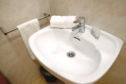 巴塞罗那Homenfun Barcelona Sagrada Familia Lepanto的浴室设有白色水槽和毛巾
