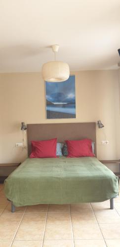 卡塔赫纳Camping Naturista El Portús - Nudist FKK的一间卧室配有一张带两个红色枕头的床