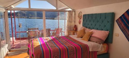 普诺Uros Titicaca coila lodge的一间卧室配有一张床,享有水景
