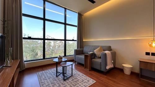 塔伊夫مساكن خاصة بتصميم فندقي ووصول ذاتي的带沙发和大窗户的客厅
