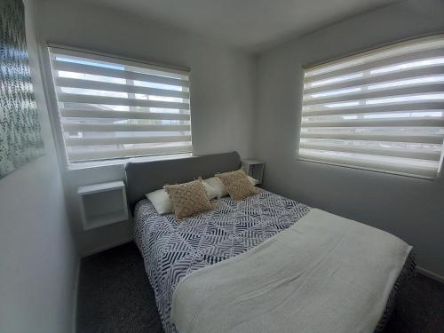 蒙特港Cabañas Cerca del Centro的一间卧室设有一张床和两个窗户。