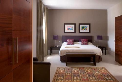 卡门港Beautiful Villa Ambar的一间卧室设有床和两张桌子,还有一扇门