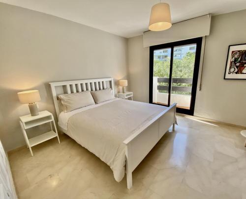 马贝拉Escape to Serenity - 3 Bedroom Townhouse by the Sea!的卧室设有一张白色大床和一扇窗户。