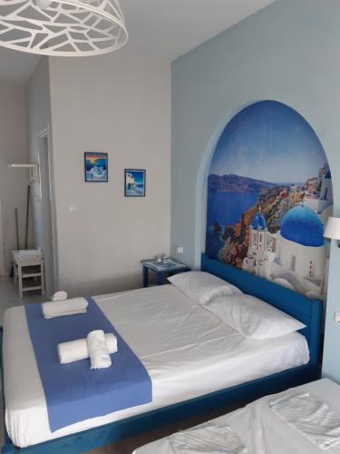 希维利Victoria's Blue studios的一间卧室配有一张带绘画作品的蓝色和白色的床