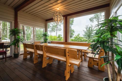 莫雷泰Senelio Romo Sodyba的用餐室设有长木桌和窗户。