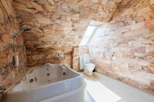 维堡帕拉兹酒店的带浴缸和卫生间的浴室。