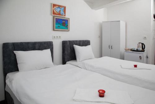 伊斯坦布尔Noya Suites的一间客房的两张白色床,上面有红色蜡烛
