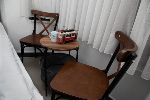 伊斯坦布尔Noya Suites的客房设有两把椅子和一张桌子,上面配有咖啡壶