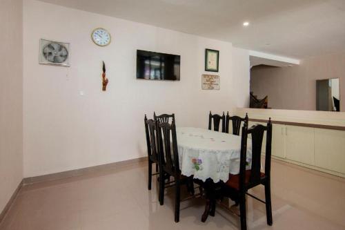 PangururanHotel Wisata Samosir By Helocus的用餐室配有桌椅和墙上的时钟