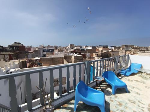 索维拉Riad Dar Sebta的阳台设有蓝色椅子,享有城市美景。