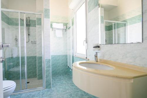 丽都迪萨维奥Hotel de Paris的一间带水槽、淋浴和卫生间的浴室