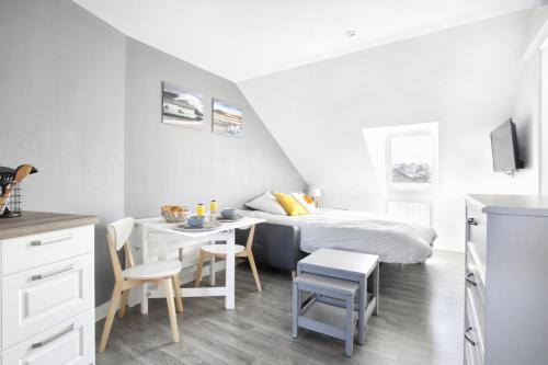 瑟堡La Hague - Second Souffle - Cherbourg的卧室配有一张床和一张桌子及椅子