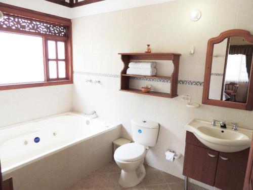 莱瓦镇Hotel Villa Cristina的带浴缸、卫生间和盥洗盆的浴室