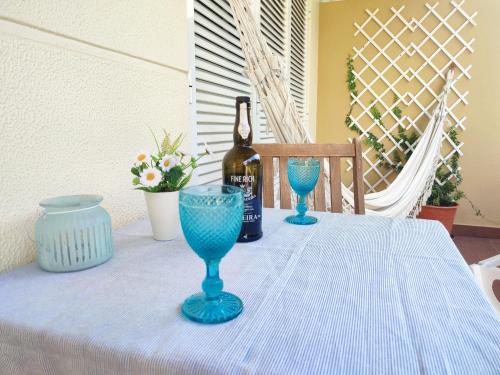 卡尼索Refugio Madeira的一张桌子,上面放着一瓶葡萄酒和两杯蓝玻璃杯