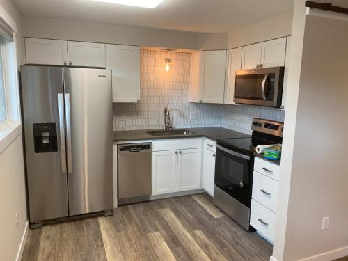 斯波坎谷Valley Escape in Quiet Area Neighborhood的厨房配有白色橱柜和不锈钢冰箱