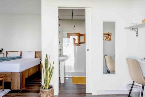 滨海罗克塔斯Mi Cortijo hotel de playa的卧室配有1张床、1张桌子和1把椅子