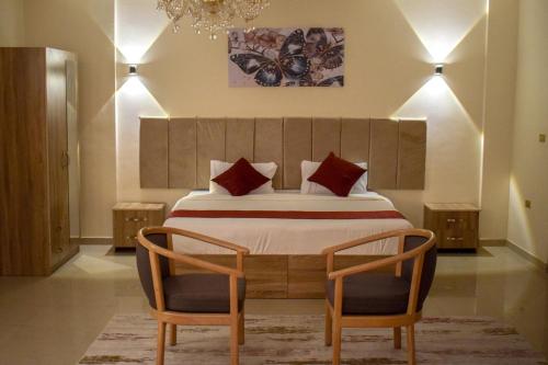瓦迪穆萨Twilight Hotel Petra的一间卧室配有一张大床和两把椅子