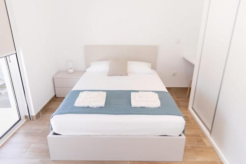 塞洛里库迪巴什图Refugio das Vinhas的一间卧室配有两张带毛巾的床