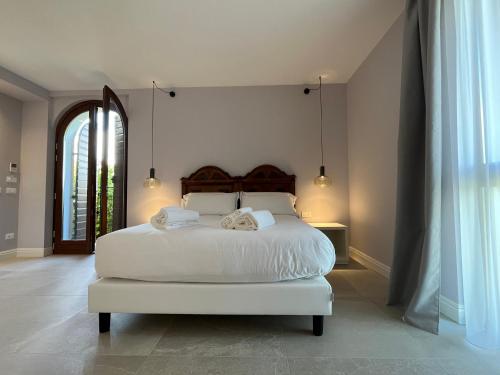 拉齐塞Agriturismo La Rondinella的卧室配有白色的床和2条毛巾