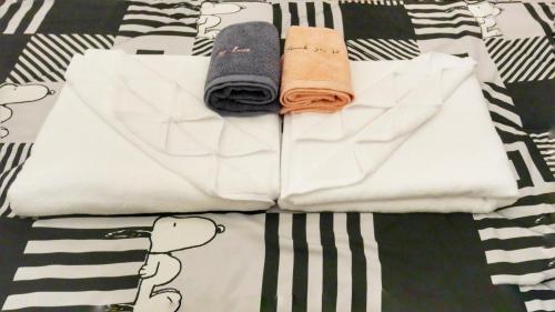 班佩Yawee & Jo Guesthouse的床上的一大堆毛巾和滑板