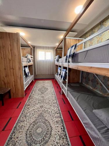 奇姆肯特InJoy hostel的客房设有两张双层床,铺有红色瓷砖地板。