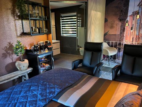 莱森Luxe Mediterraanse Suite的一间卧室配有两把椅子和一张床