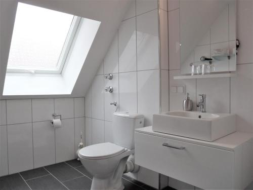 维尔茨堡布雷姆酒店的白色的浴室设有卫生间和水槽。