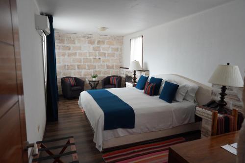 Colchani萨尔露娜萨拉达酒店的一间卧室配有一张带蓝色枕头的大床