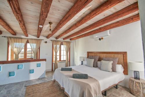 蒂纳霍Casa Rural Nel的一间卧室设有一张大床和木制天花板。