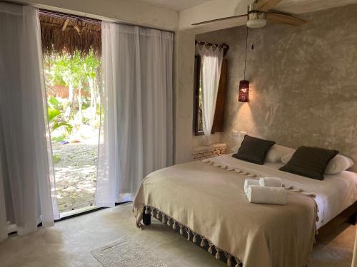 ChemuyilVerdeAmar Eco Lodge Jungle Retreat的一间卧室设有一张床和一个大窗户